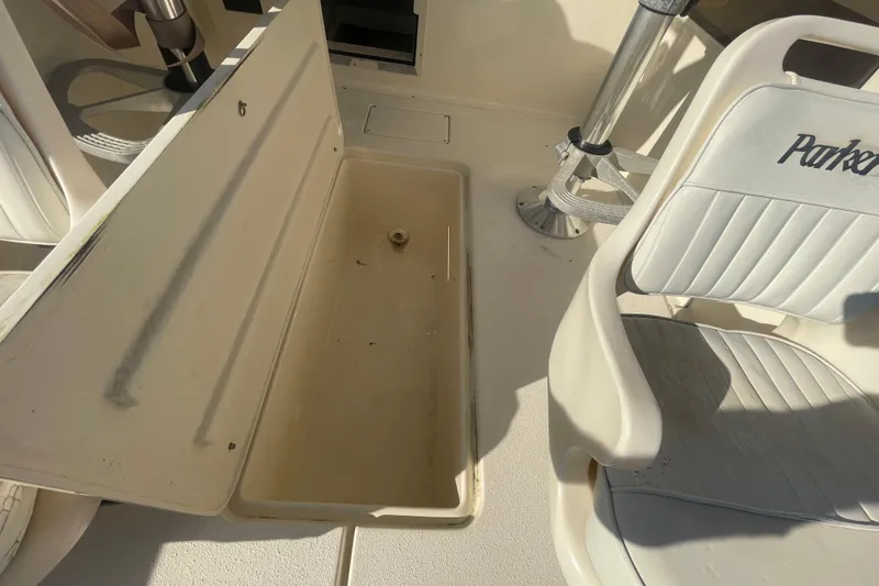 Slide: The Image of Open storage compartment on a 2006 Parker 2310 boat with white seating. - 23