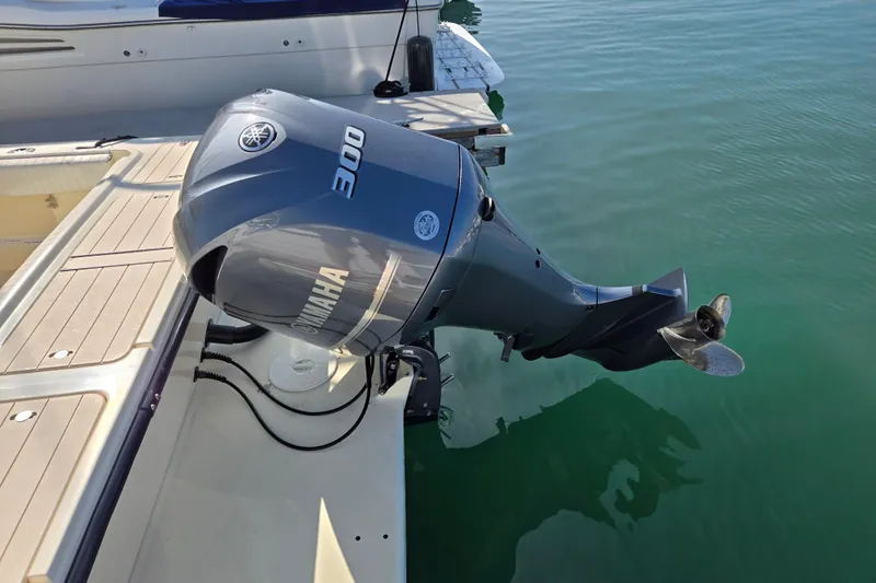 Slide: The Image of Outboard motor on a 2006 Parker 2310 boat, docked in clear water. - 24
