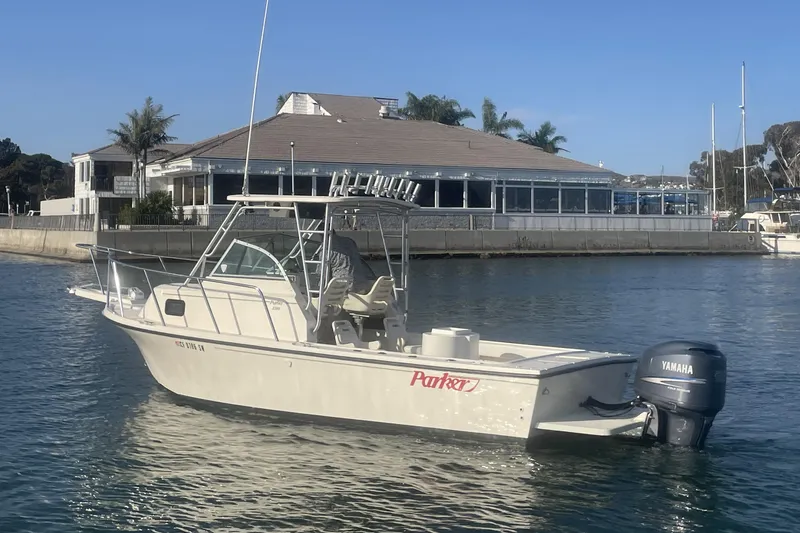 Slide: The Image of A 2006 Parker 2310 boat with Yamaha engine docked near a waterfront building. - 3