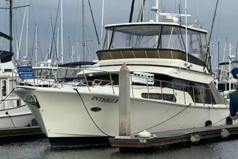 The Image of 1999 Mikelson 50 Sportfisher yacht docked at marina with sailboats in background. - 0