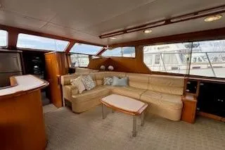 Slide: The Image of Luxurious interior of 1999 Mikelson 50 Sportfisher yacht with beige seating and wooden accents. - 13