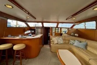 Slide: The Image of Interior of 1999 Mikelson 50 Sportfisher yacht with cozy seating and bar area. - 14