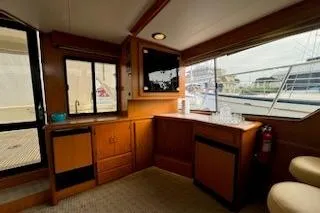 Slide: The Image of Interior of 1999 Mikelson 50 Sportfisher yacht with wood cabinetry and large windows. - 16