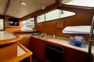 Slide: The Image of Interior of 1999 Mikelson 50 Sportfisher yacht with wooden cabinetry and modern amenities. - 18