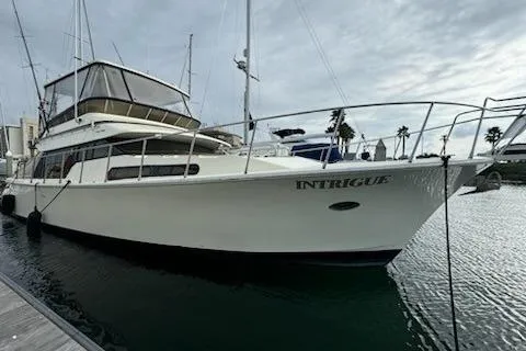 Slide: The Image of 1999 Mikelson 50 Sportfisher yacht named "Intrigue" docked in a marina. - 2