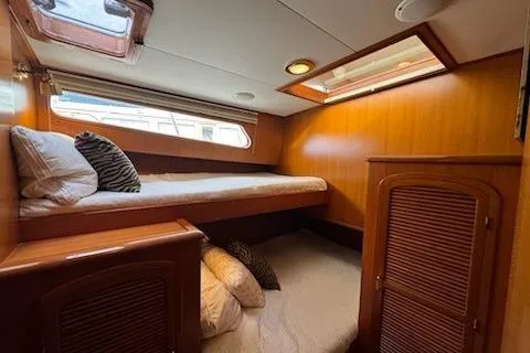 Slide: The Image of 1999 Mikelson 50 Sportfisher cabin with wooden interior and bunk beds. - 21