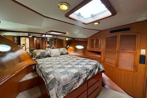 Slide: The Image of Luxurious cabin interior of 1999 Mikelson 50 Sportfisher yacht with cozy bed and wood finish. - 22
