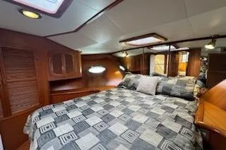 Slide: The Image of 1999 Mikelson 50 Sportfisher cabin with cozy bed and wooden interior. - 23