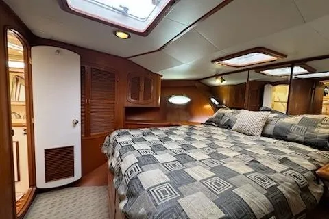 Slide: The Image of 1999 Mikelson 50 Sportfisher cabin with cozy bed and wooden interior design. - 24
