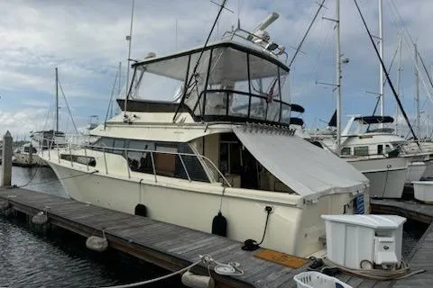 Slide: The Image of 1999 Mikelson 50 Sportfisher yacht docked at a marina, featuring a spacious flybridge. - 5