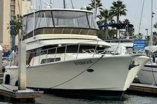 Slide: The Image of 1999 Mikelson 50 Sportfisher yacht docked at marina with palm trees in background. - 9