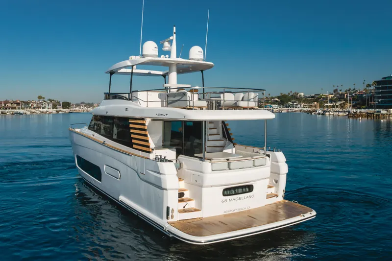 Slide: The Image of 2023 Azimut Magellano 66 yacht cruising in a serene marina setting. - 3