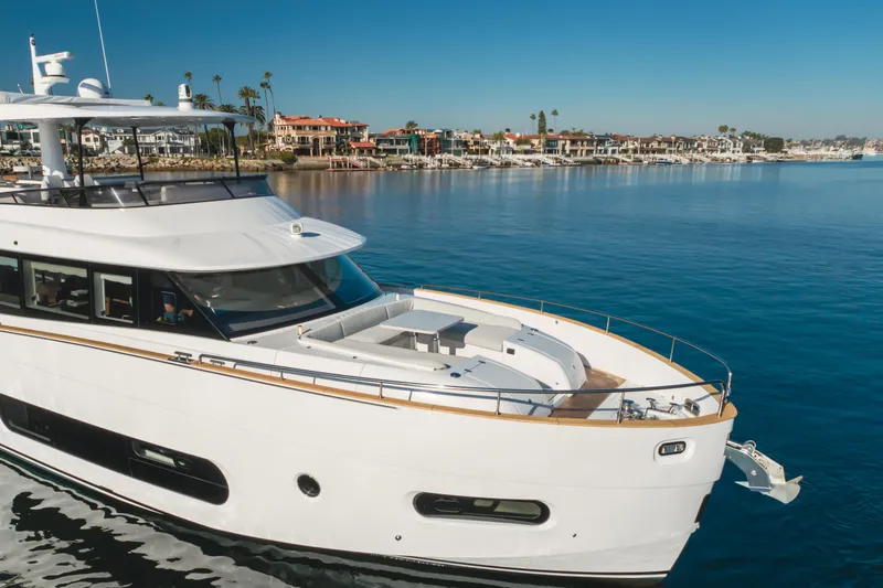 Slide: The Image of 2023 Azimut Magellano 66 yacht cruising near coastal homes under clear blue skies. - 4