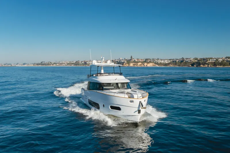 Slide: The Image of 2023 Azimut Magellano 66 yacht cruising on open water under clear blue skies. - 5