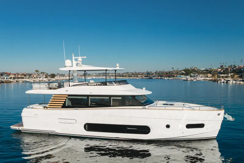 Slide: The Image of 2023 Azimut Magellano 66 yacht cruising in a scenic harbor. - 8