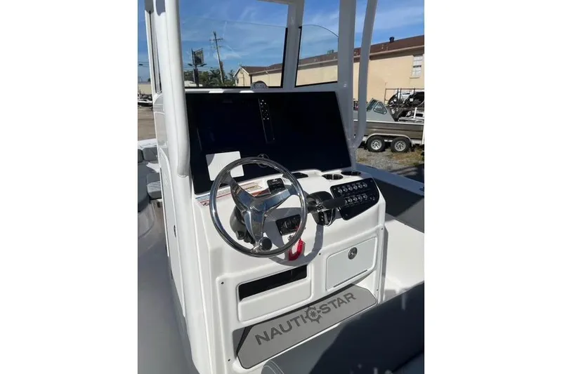 Slide: The Image of 2026 NauticStar 251 Hybrid boat dashboard with steering wheel and controls. - 10