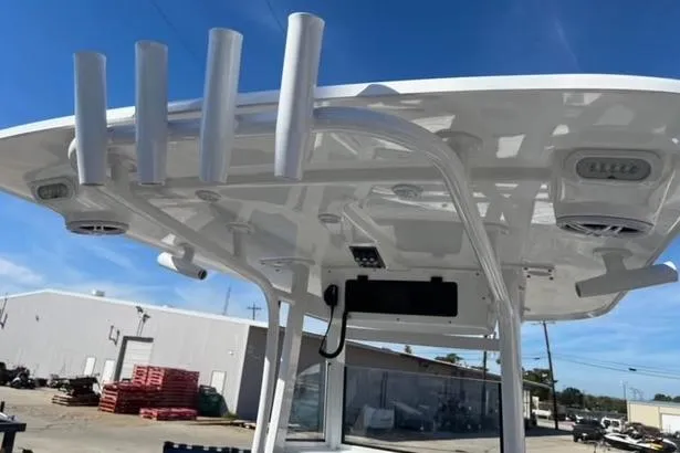 Slide: The Image of 2026 NauticStar 251 Hybrid boat with T-top and rod holders in a marina setting. - 4