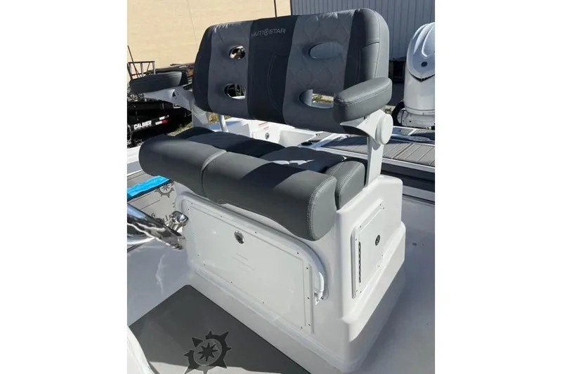 Slide: The Image of 2026 NauticStar 251 Hybrid boat seat with gray upholstery and storage compartment. - 9