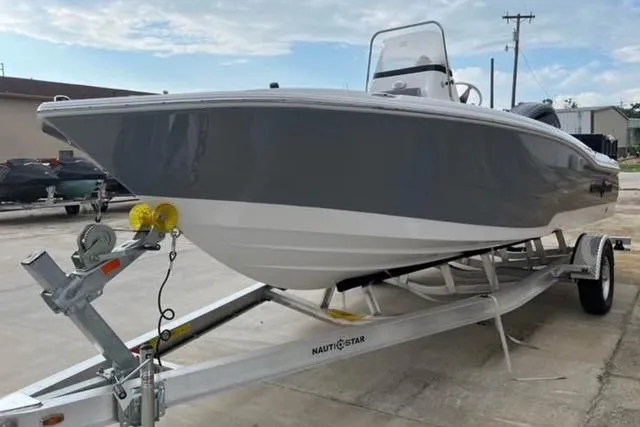 Slide: The Image of 2026 NauticStar 191 Hybrid boat on trailer, gray and white design, parked outdoors. - 3