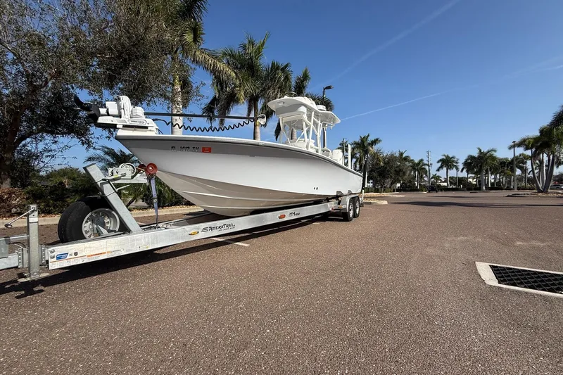 The Image of 2024 SeaVee 270Z boat on trailer, parked under clear blue sky with palm trees. - 1