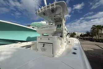 Slide: The Image of 2024 SeaVee 270Z boat with center console, docked under a partly cloudy sky. - 8