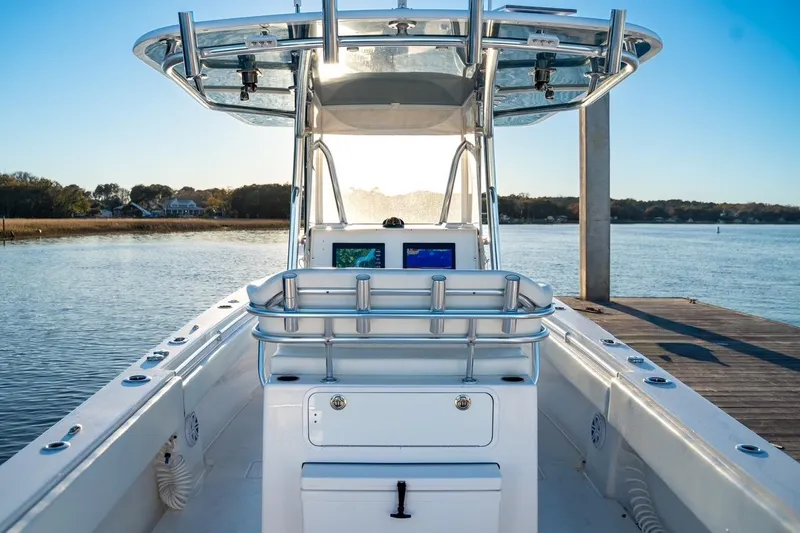Slide: The Image of 2020 Contender 32 ST boat docked, featuring helm and navigation screens, with scenic water view. - 13