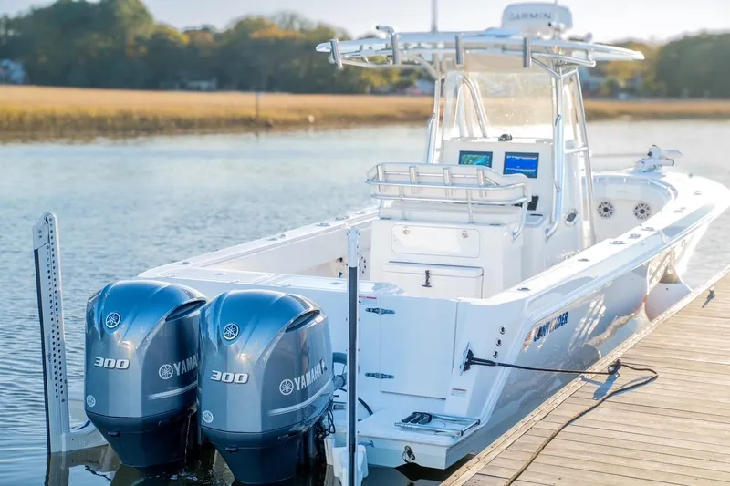 Slide: The Image of 2020 Contender 32 ST boat with twin Yamaha 300 engines docked on calm water. - 19