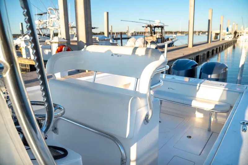 Slide: The Image of 2020 Contender 32 ST boat interior at marina, featuring seating and twin engines. - 34