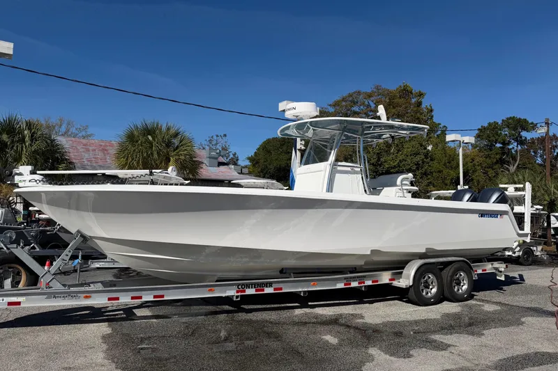 Slide: The Image of 2020 Contender 32 ST boat on trailer, parked outdoors under clear blue sky. - 44