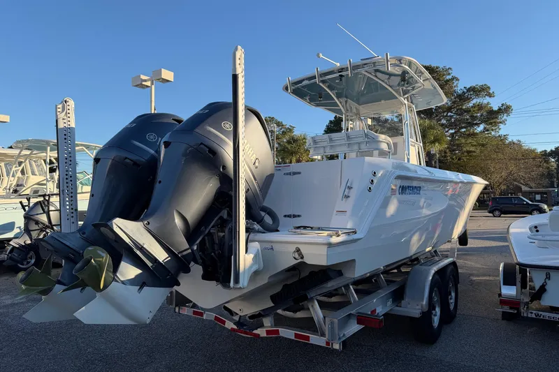 Slide: The Image of 2020 Contender 32 ST boat on trailer with dual outboard engines, parked outdoors. - 47