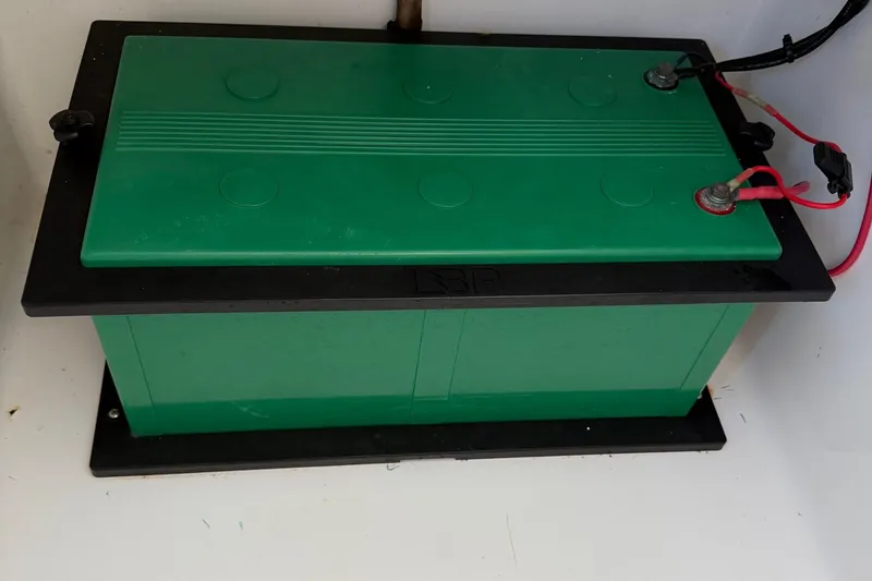 Slide: The Image of Green marine battery in a 2020 Contender 32 ST boat, connected with red cables. - 68