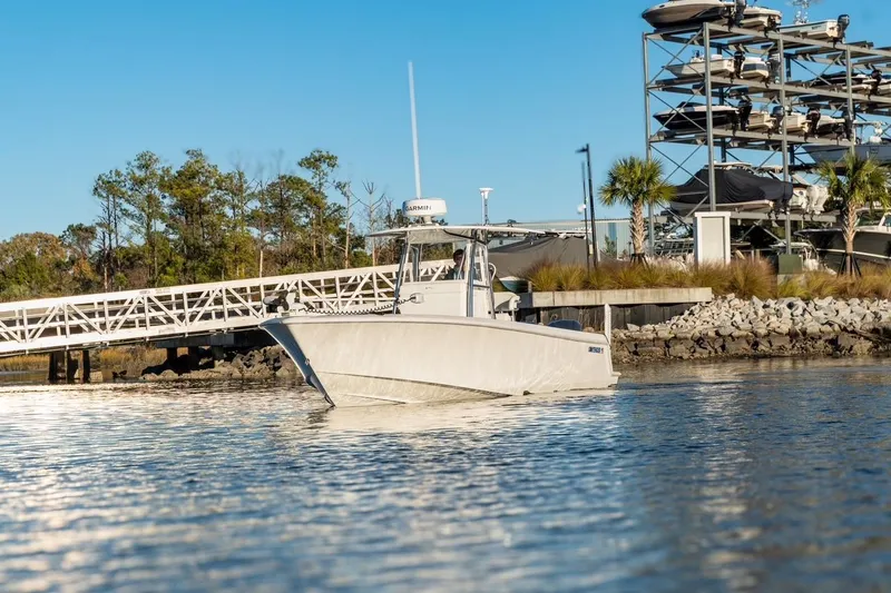 Slide: The Image of 2020 Contender 32 ST boat docked near a marina with stacked boats. - 7