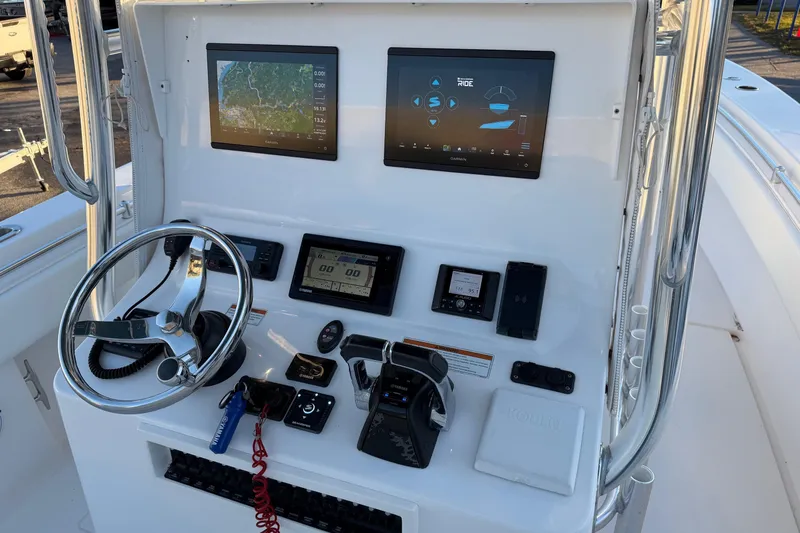 Slide: The Image of Control panel of a 2020 Contender 32 ST boat with navigation screens and steering wheel. - 70