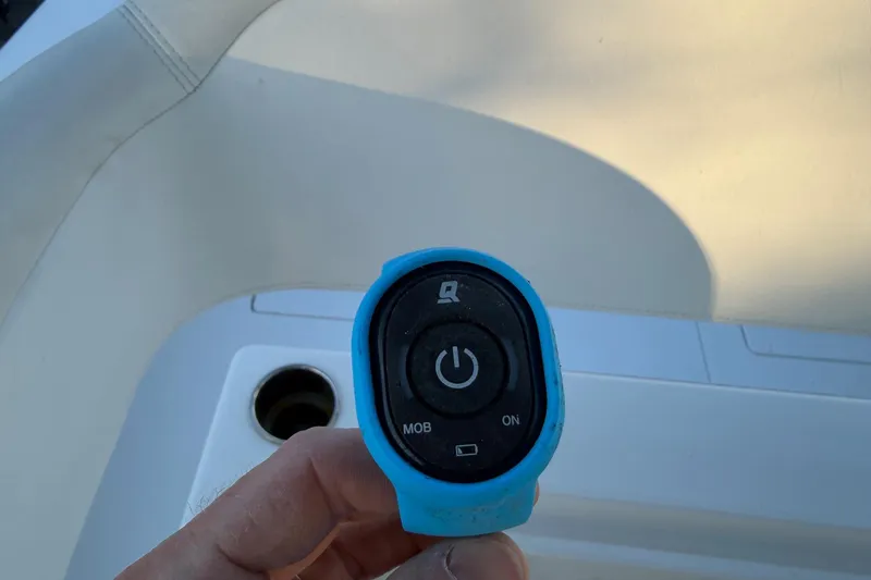 Slide: The Image of Hand holding a blue remote control on a 2020 Contender 32 ST boat. - 81