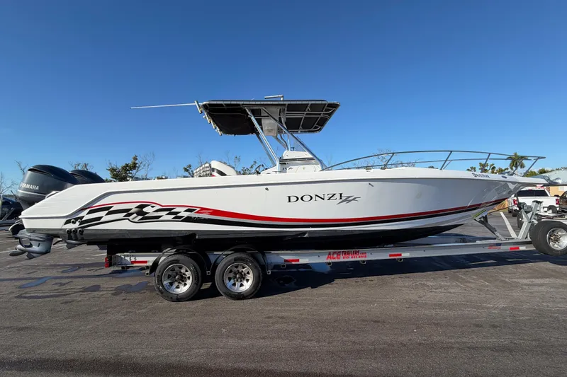 The Image of 1999 Donzi 35 ZF Cuddy boat on trailer, side view, clear sky background. - 0