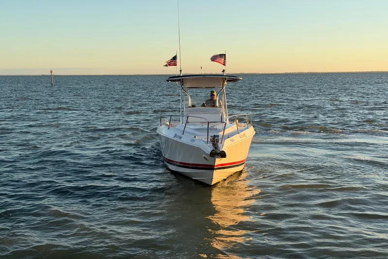 Slide: The Image of 1999 Donzi 35 ZF Cuddy boat cruising on calm waters at sunset. - 12