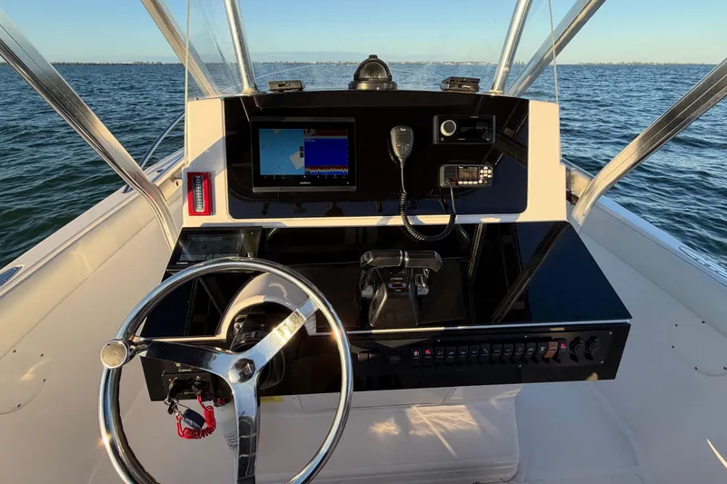 Slide: The Image of 1999 Donzi 35 ZF Cuddy boat dashboard with steering wheel and navigation equipment. - 13