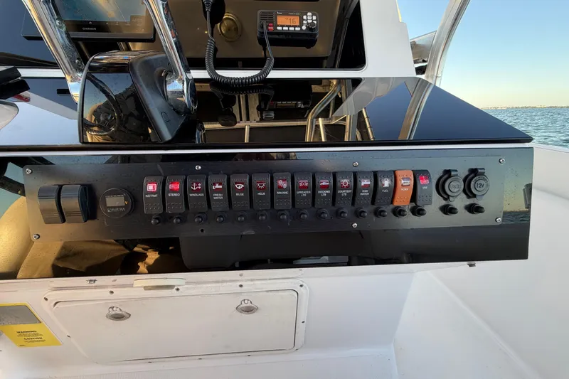 Slide: The Image of Control panel of a 1999 Donzi 35 ZF Cuddy boat with various switches and gauges. - 14
