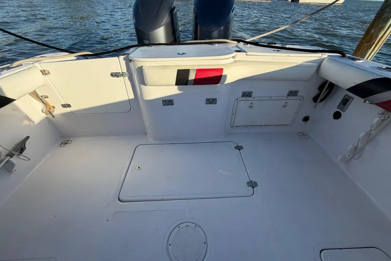 Slide: The Image of 1999 Donzi 35 ZF Cuddy boat deck with storage compartments and twin engines. - 23