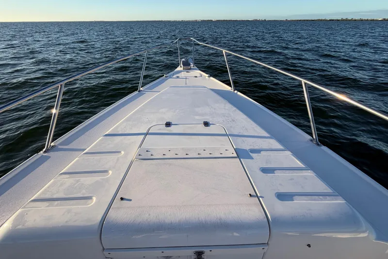 Slide: The Image of 1999 Donzi 35 ZF Cuddy boat deck on open water, clear sky. - 26