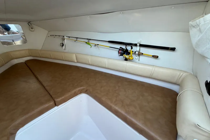 Slide: The Image of Interior of 1999 Donzi 35 ZF Cuddy with fishing rods and cushioned seating. - 29
