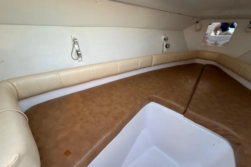 Slide: The Image of 1999 Donzi 35 ZF Cuddy cabin interior with beige seating and storage area. - 30