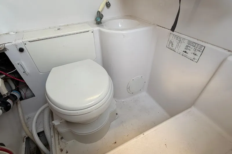 Slide: The Image of 1999 Donzi 35 ZF Cuddy boat bathroom with toilet and sink. - 32