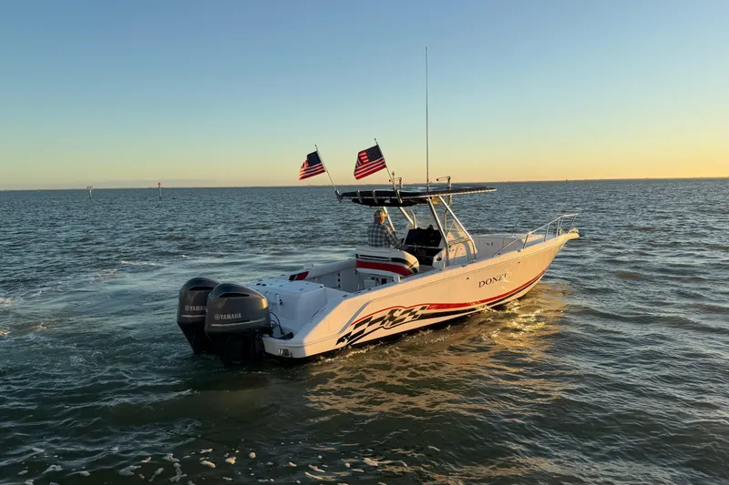 Slide: The Image of 1999 Donzi 35 ZF Cuddy boat cruising on open water at sunset. - 7