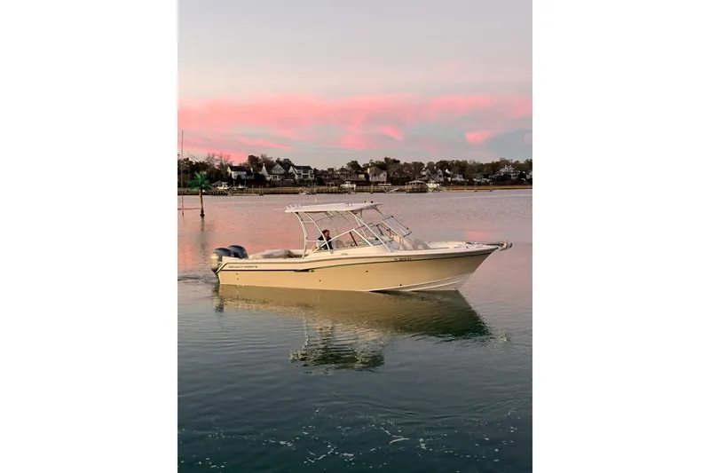 The Image of 2012 Grady-White Freedom 275 boat on calm water at sunset with pink sky. - 1