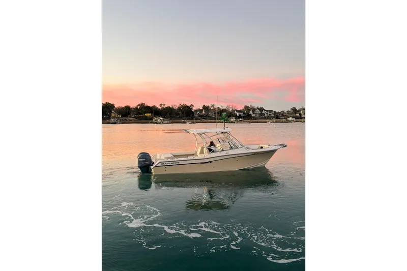 Slide: The Image of 2012 Grady-White Freedom 275 boat on calm water at sunset. - 17