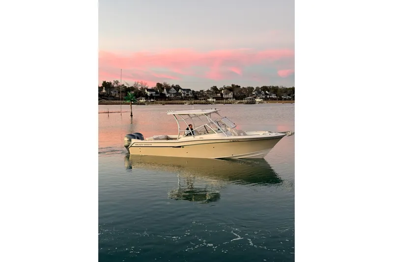 Slide: The Image of 2012 Grady-White Freedom 275 boat cruising on calm water at sunset. - 19