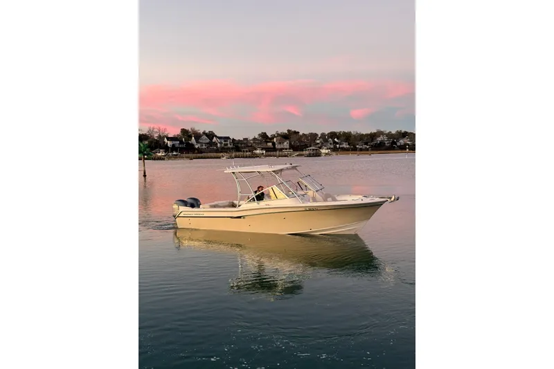 Slide: The Image of 2012 Grady-White Freedom 275 boat on calm water at sunset with pink sky. - 20