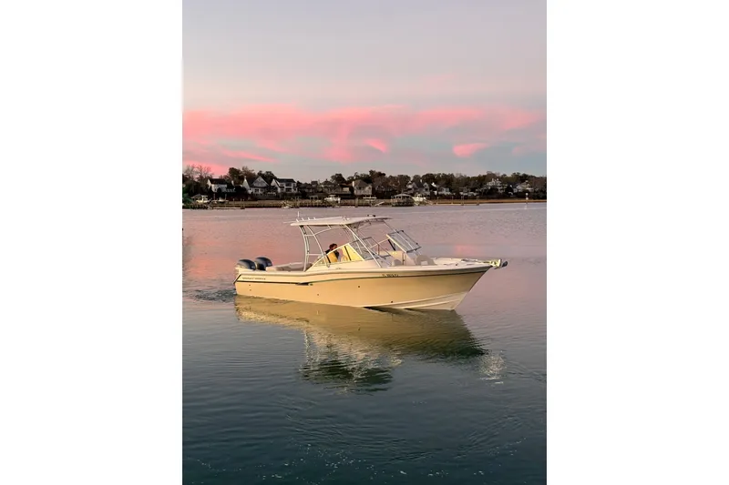 Slide: The Image of 2012 Grady-White Freedom 275 boat on calm water at sunset. - 22