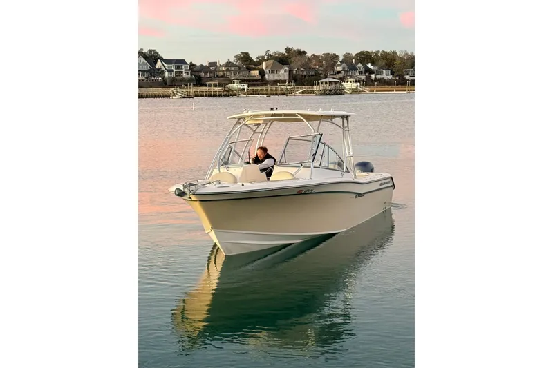 Slide: The Image of 2012 Grady-White Freedom 275 boat cruising on calm water at sunset. - 24